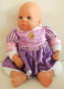 Puppe mit violettem Kleid